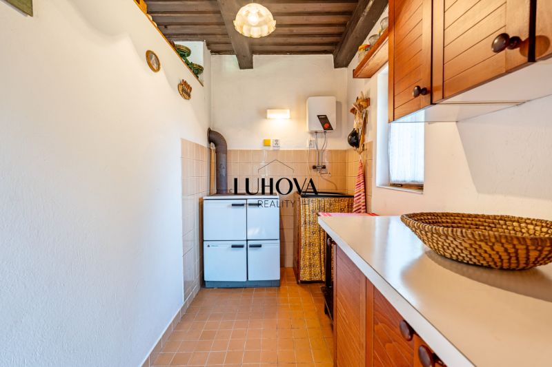 A kitchenette in a cabin with white walls, brown cabinets, and appliances.