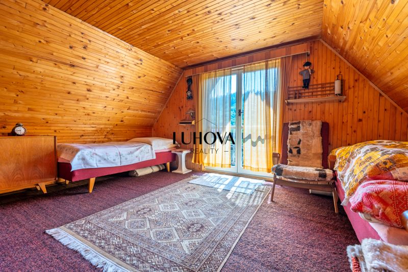 Wooden paneling, carpets, and a bed in the interior of the cabin create a cozy atmosphere.