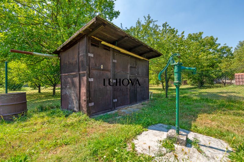 Wooden gazebo and hand pump in the garden at the cottage in Lazy pod Makytou, Dubková.