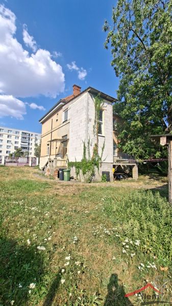 A family house on Levická Street in Vráble with abundant greenery and a brick roof.
