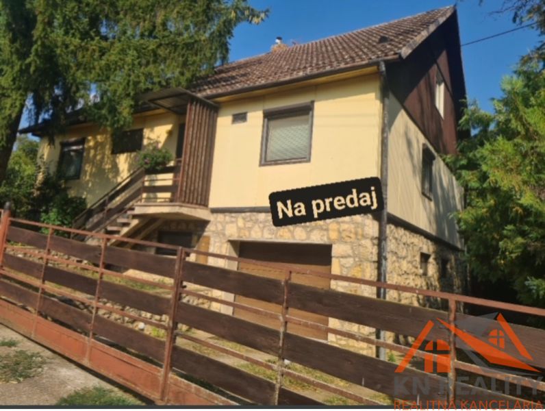 A family house in Svodín, with stone foundations and a wooden fence, is for sale.