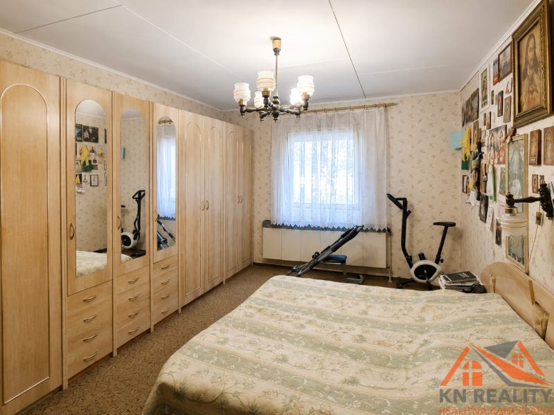 A bedroom in a family house with a large wardrobe, a bed, and exercise equipment.
