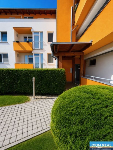 A colorful facade of a building surrounded by green shrubs on Cherry Street in Chorvátsky Grob.