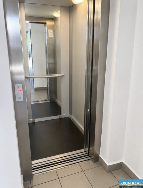 Opening elevator doors with a steel frame and a mirror inside.