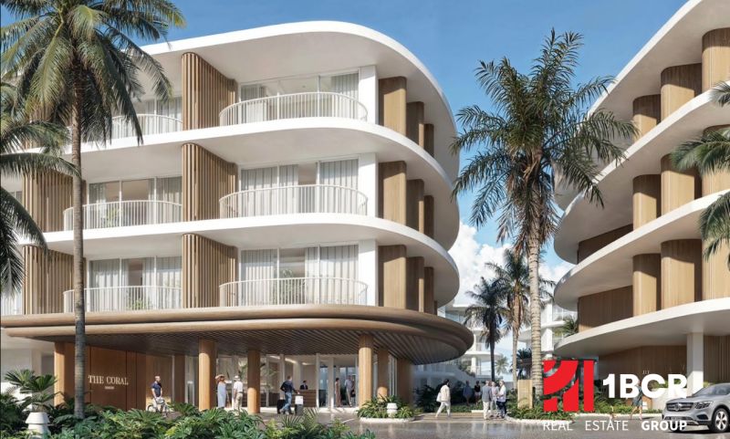 Construction of apartments in Surat Thani with curved balconies and palm trees in the background.