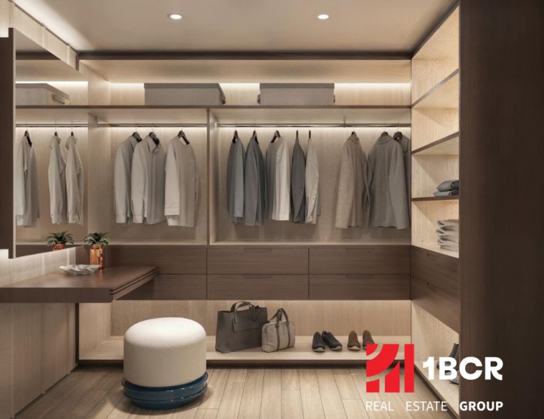 A wardrobe in a 2-room apartment with a wooden decor floor and subtle lighting.
