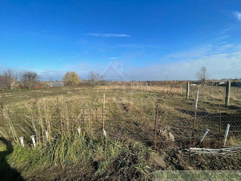 Land in Tvrdošovce with fencing, grass, and surrounding landscape for a family house.