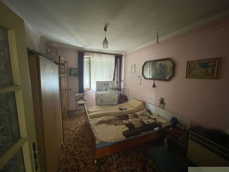 A room in a family house with a carpet, decorations, and antique furniture.