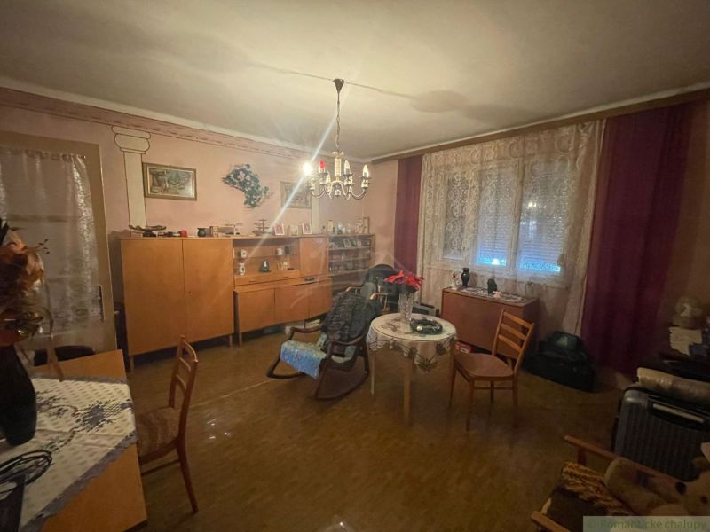 Living room in a family house with furniture, curtains, and a wooden decor floor.
