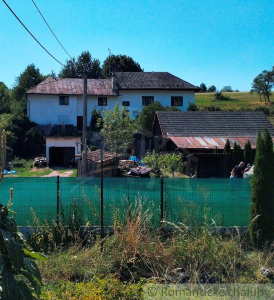 A family house in Stará Turá with a garden, fencing, and extensions, with a view of the countryside.
