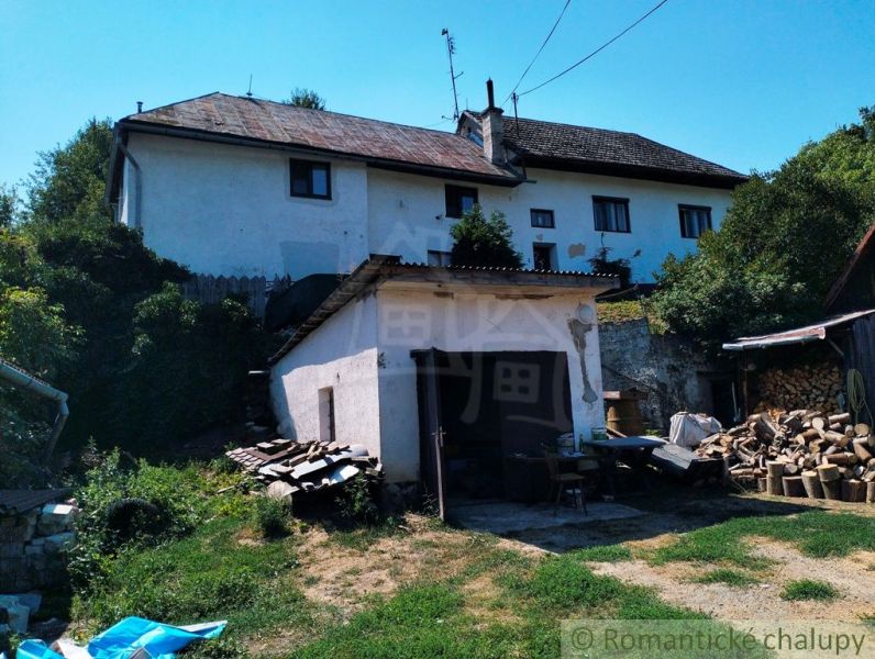 A family house in Stará Turá with a garage and cut wood in the yard.