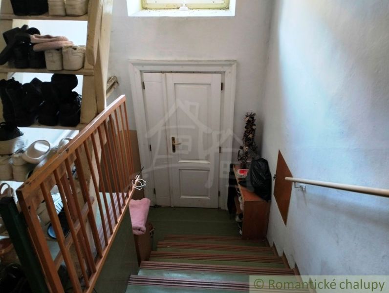 A staircase with a shoe rack and white doors in a family house.