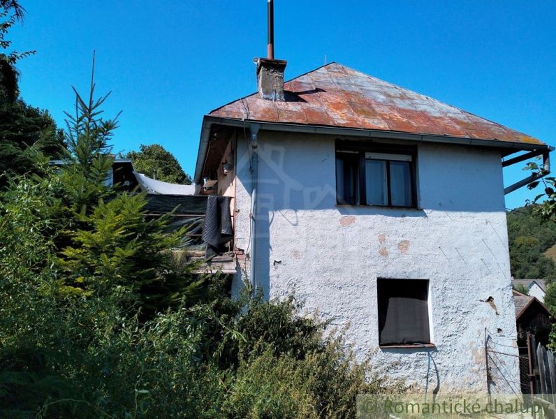 A family house in Stará Turá with a worn-out roof and overgrown surroundings.