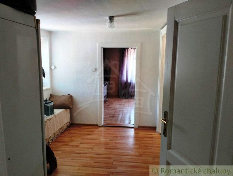 The interior of a family house with a wooden decor floor, light walls, and doors.