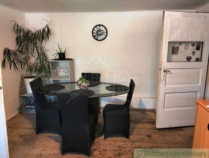 Dining area in a family house with wooden flooring and a glass table.