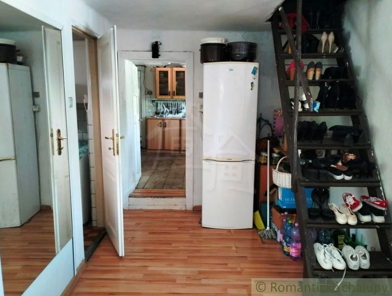Interior of a family house with a staircase, mirror, and wooden decor flooring.