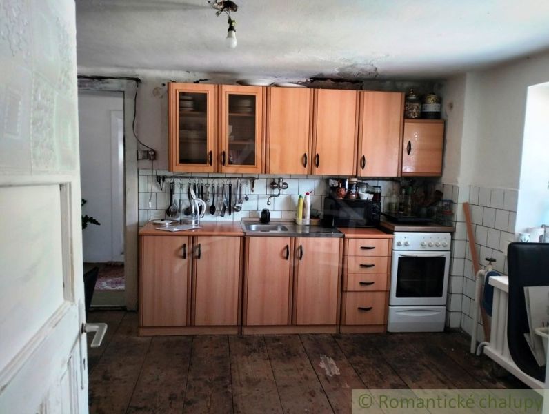 A kitchen in a family house with a wooden decor floor and wooden cabinets.