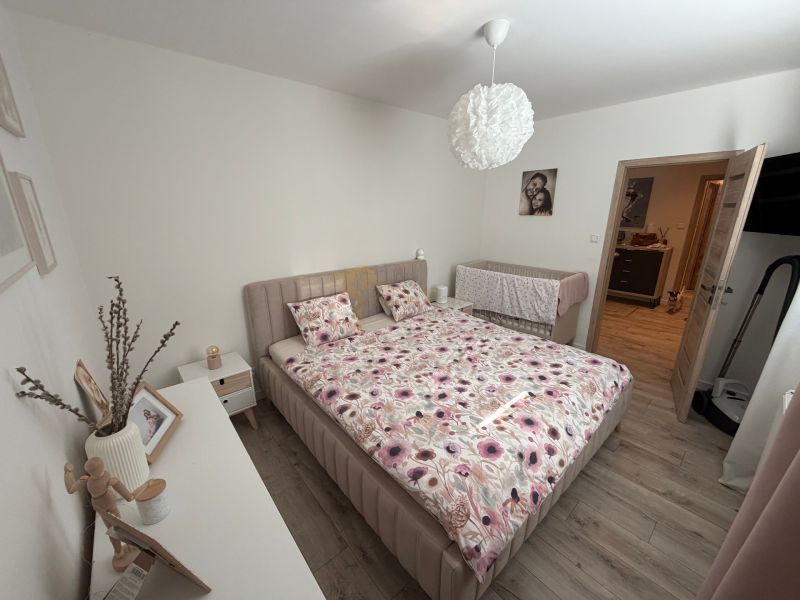 Bedroom in a 3-room apartment with a bed and a wooden decor floor.