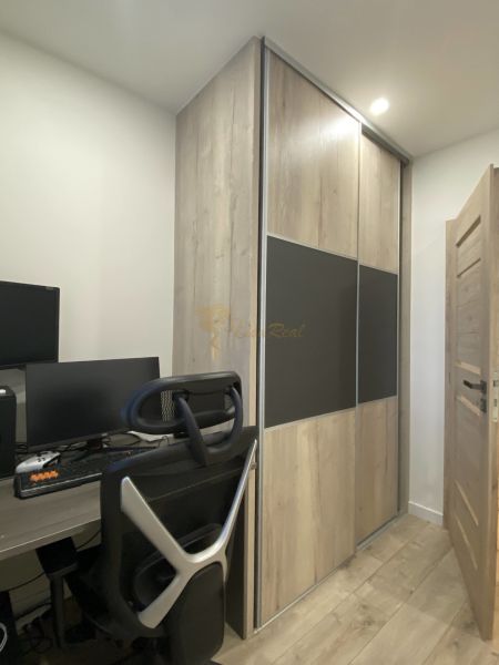 A workspace with a chair, desk, computer, and cabinet with wooden decor in a 3-room apartment.