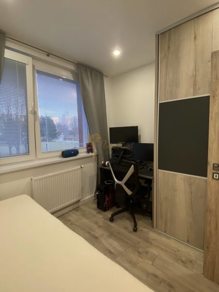 A room in a 3-room apartment with a desk, a wardrobe, and a window with blinds.