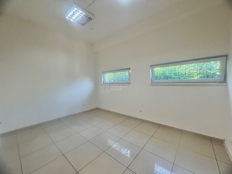A commercial space room with ceramic tiles and two windows.