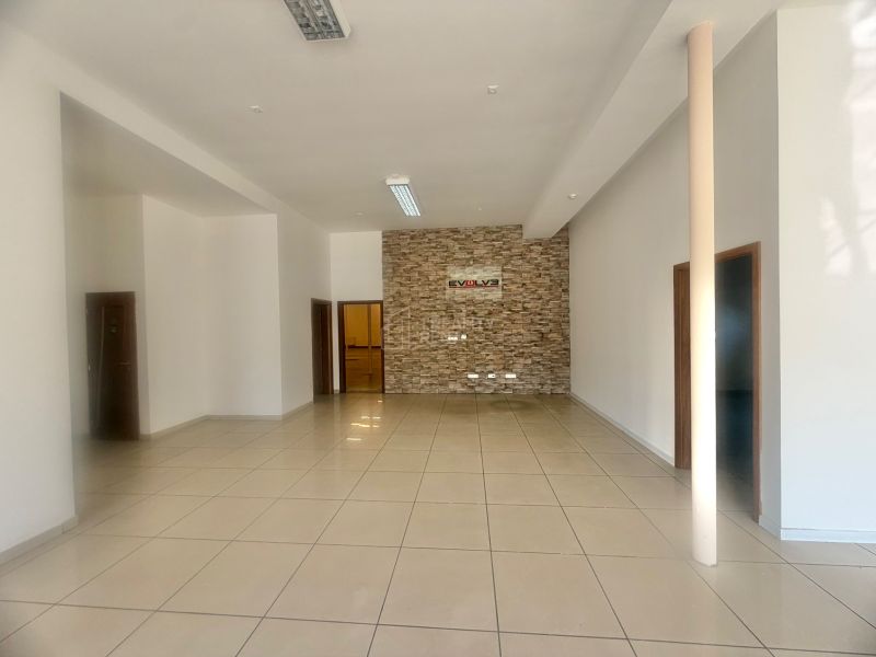 Interior of a commercial space with a stone wall and tiled floor.