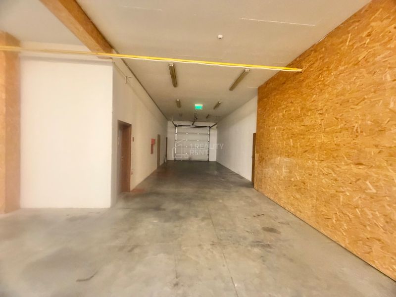 Spacious commercial spaces with concrete floors and wooden walls.