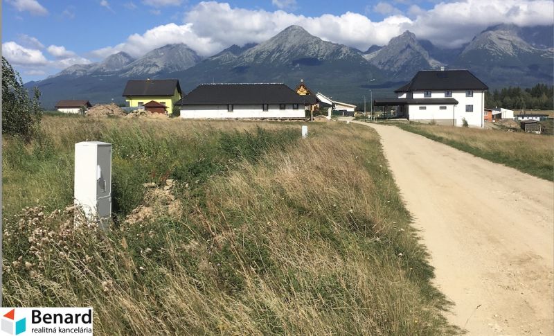 Residential plots in Mlynica with a view of the mountains and a dirt road.