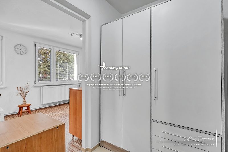 A large wardrobe, windows, and a wooden decor floor dominate the 1-room apartment.
