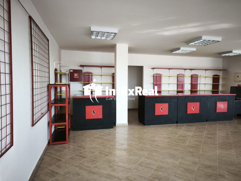 Commercial space with a counter and shelves, wood-patterned flooring, in black and red color.