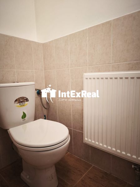 Restroom in commercial premises with tiling and a radiator.