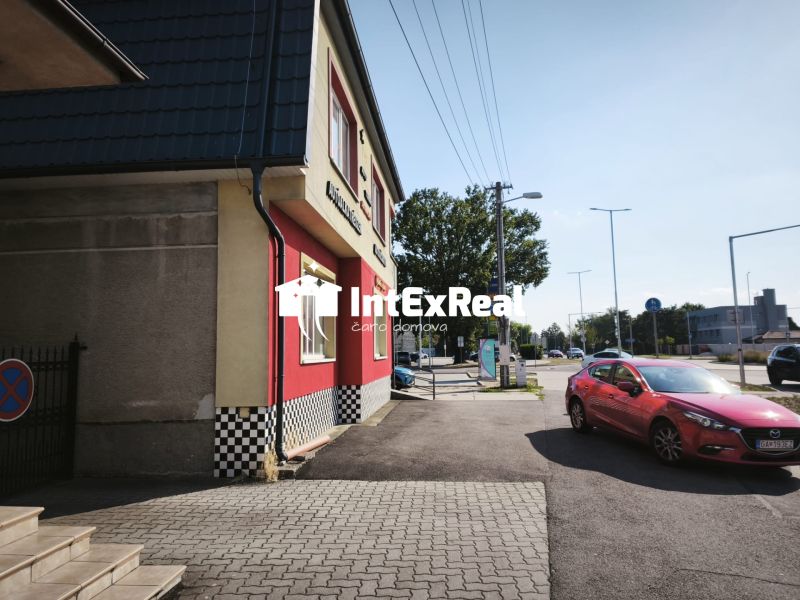 Commercial premises on SNP Street in Šaľa with a red car on the road.
