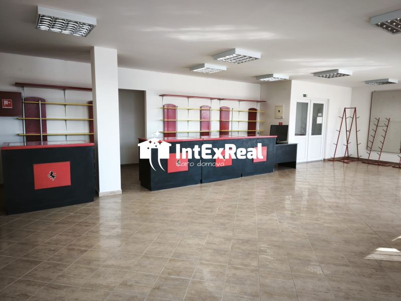 Commercial premises with tiles, black and red counters, shelves, and racks.