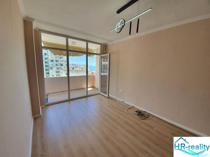 Recreational apartment with a glass wall and wooden decor flooring, access to the balcony.