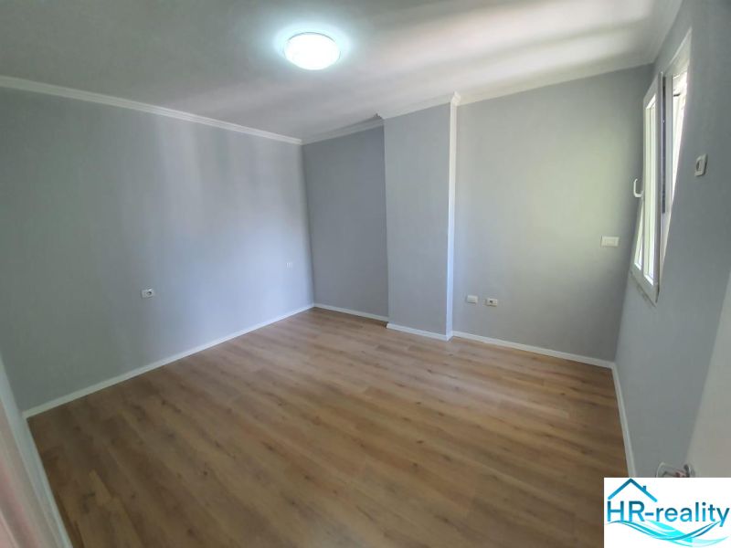 Bright room with wood-patterned flooring in a Holiday Apartment.
