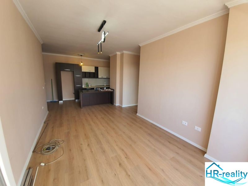A kitchen in a holiday apartment with a wooden decor floor and soft-colored walls.