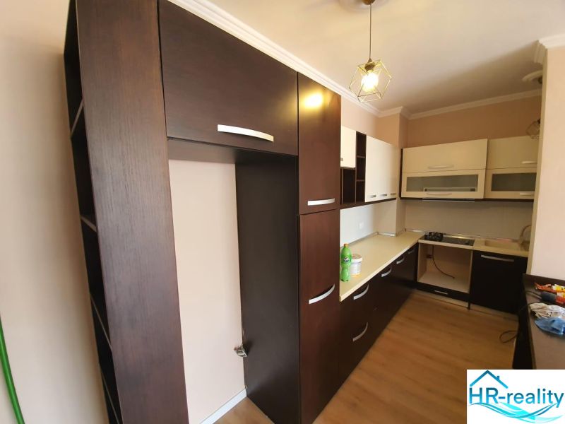 The kitchen in the holiday apartment features dark cabinets and a wooden decor floor.