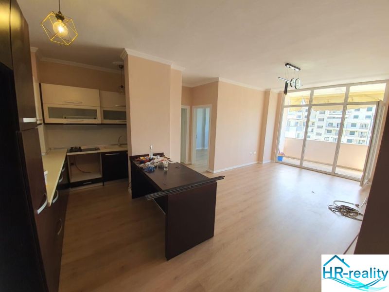 Kitchen and living room in the Holiday Apartment, floor with wood decor, balcony.