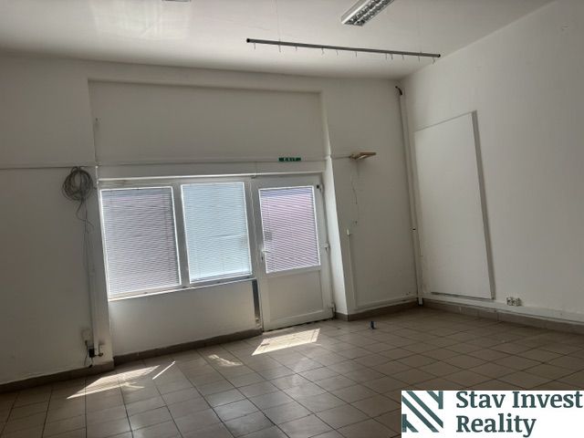 Interior of commercial spaces with large windows and tiled flooring.