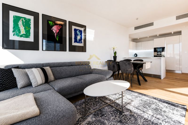 Living room in a 3-room apartment with a comfortable sofa, decorative paintings, and light furnishings.