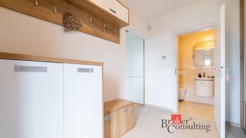 Entrance hall in a family house with wall hooks and entrance to the bathroom.