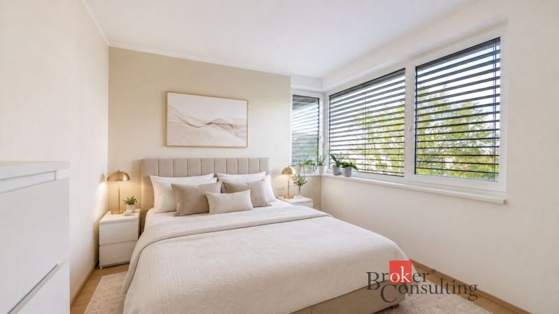 A bedroom in a family house with a comfortable bed, decor, and blinds on the windows.