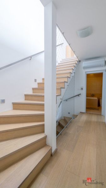 Family house with a floor with a wooden decor and a wooden staircase with a safety net.