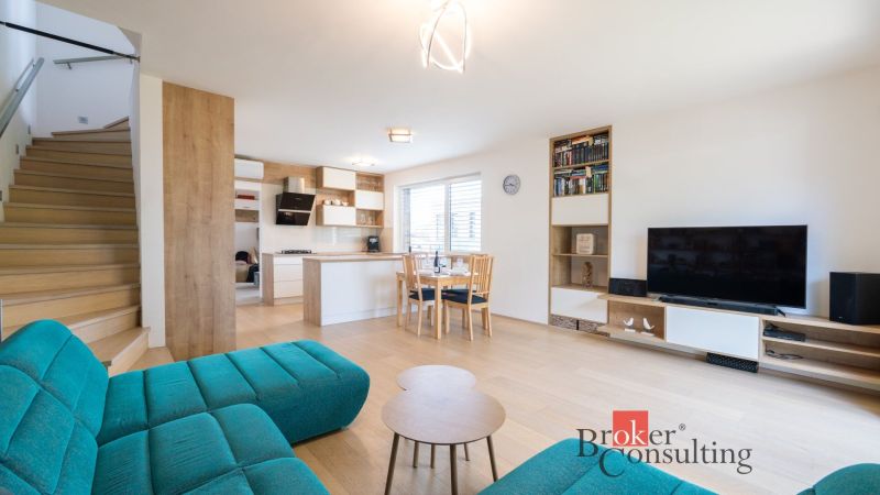 Living room with kitchen in a family house, floor with wood decor, staircase.