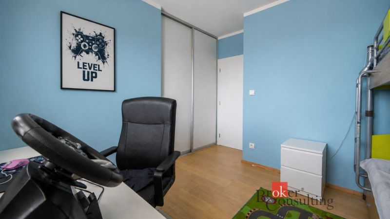 A room with blue walls, a wooden decor floor, and gaming equipment in a family house.