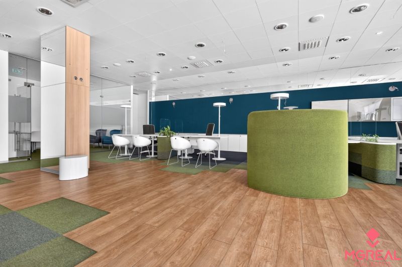 Office spaces with wood-patterned flooring and green furniture.