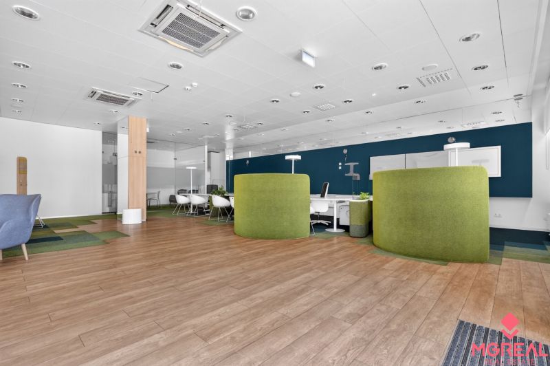 Commercial spaces with wood-patterned flooring and green partition panels.