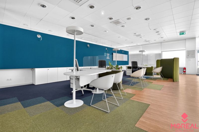 Workspace with chairs, white furniture, and wood-patterned flooring.