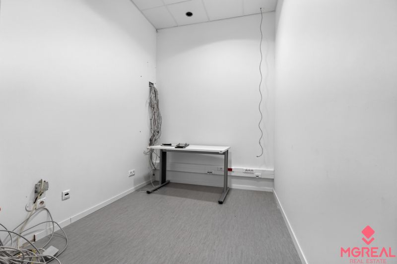 Office room with a simple desk, cables and sockets on the wall, commercial premises.