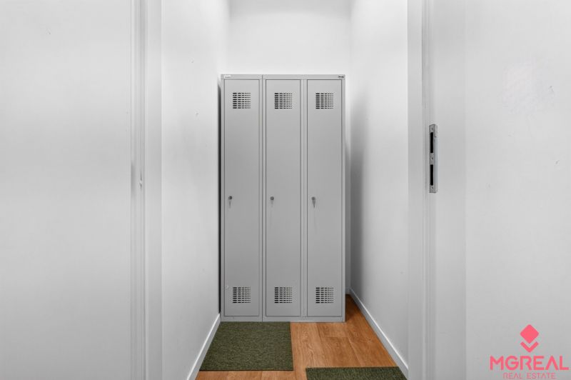 Narrow spaces with metal lockers and a wooden decor floor.